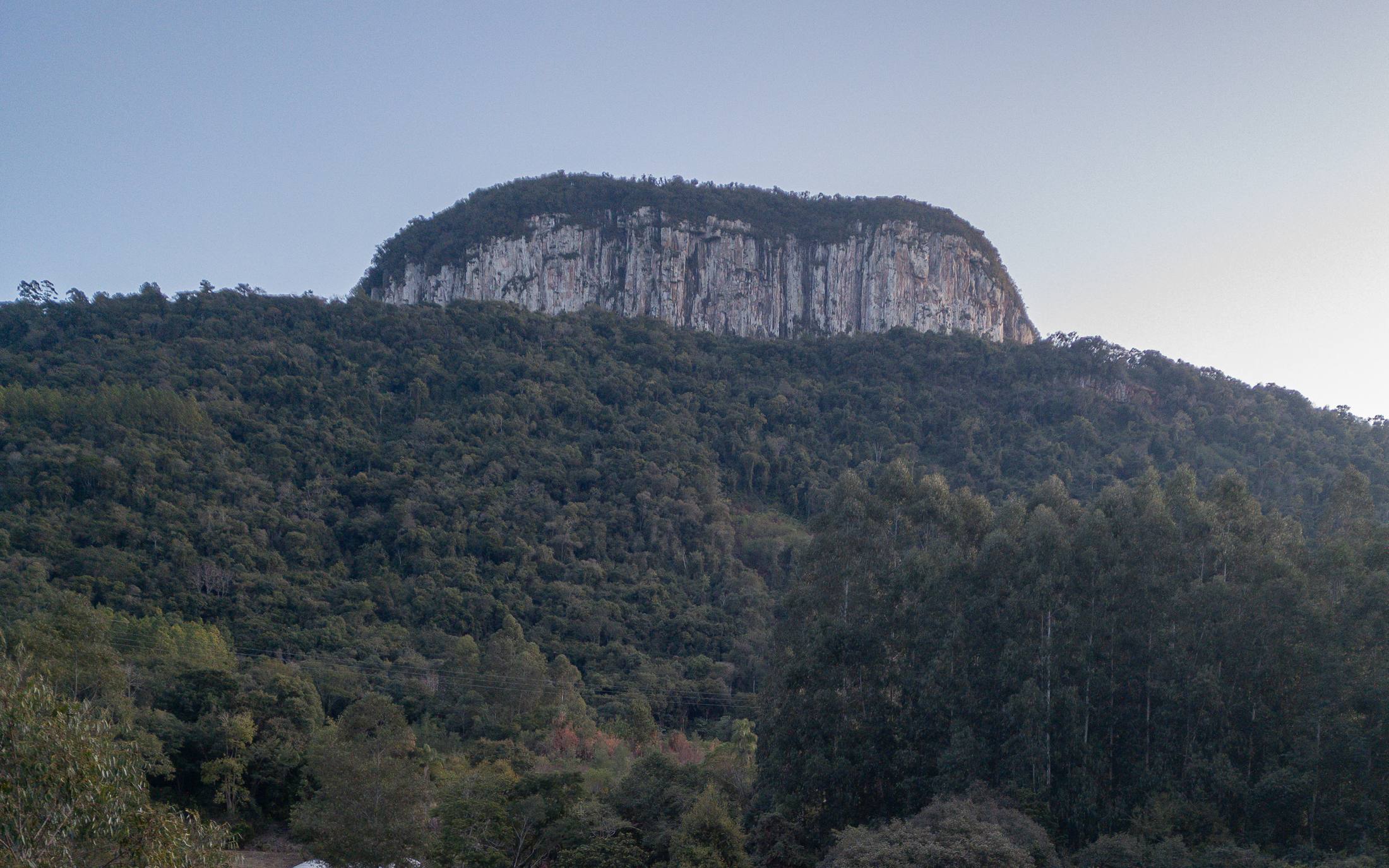 O paredão do Monte Malakoff ao entardecer, sobre a mata que cerca as cabanas